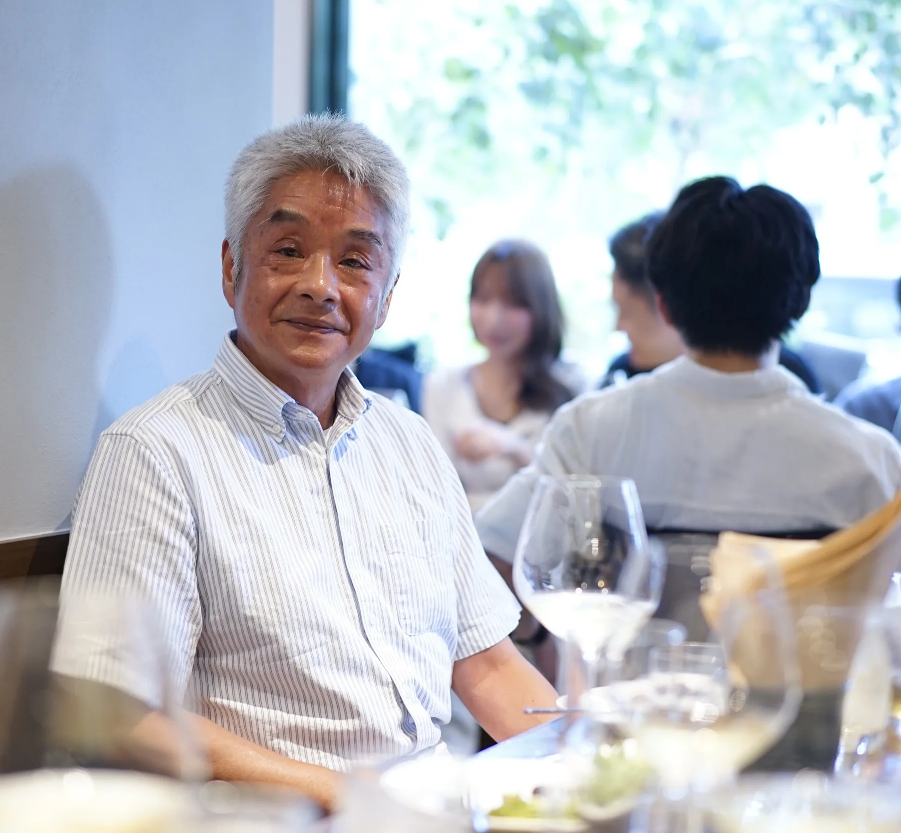 会食の場でほほえむ坂本浩